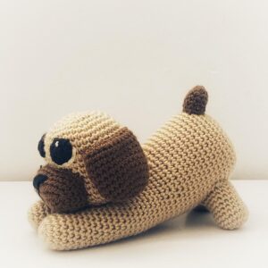 Simpático perrito a crochet en tonos marrones.