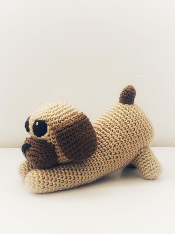 Simpático perrito a crochet en tonos marrones.