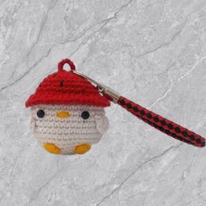 Llavero de pollito con gorrito de fresa a crochet.